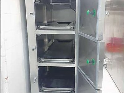 Mortuary Refrigerator — Three Cells, all three doors open showing empty tray racks, installed view