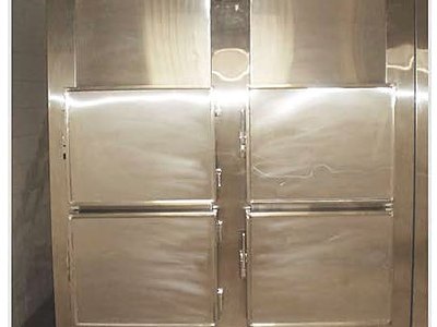 Mortuary Refrigerator — Four Cells, front view with all four doors closed, installed in a morgue room