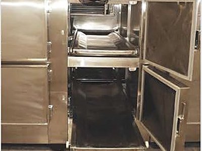 Mortuary Refrigerator — Four Cells, open doors with a body tray pulled out, installed view